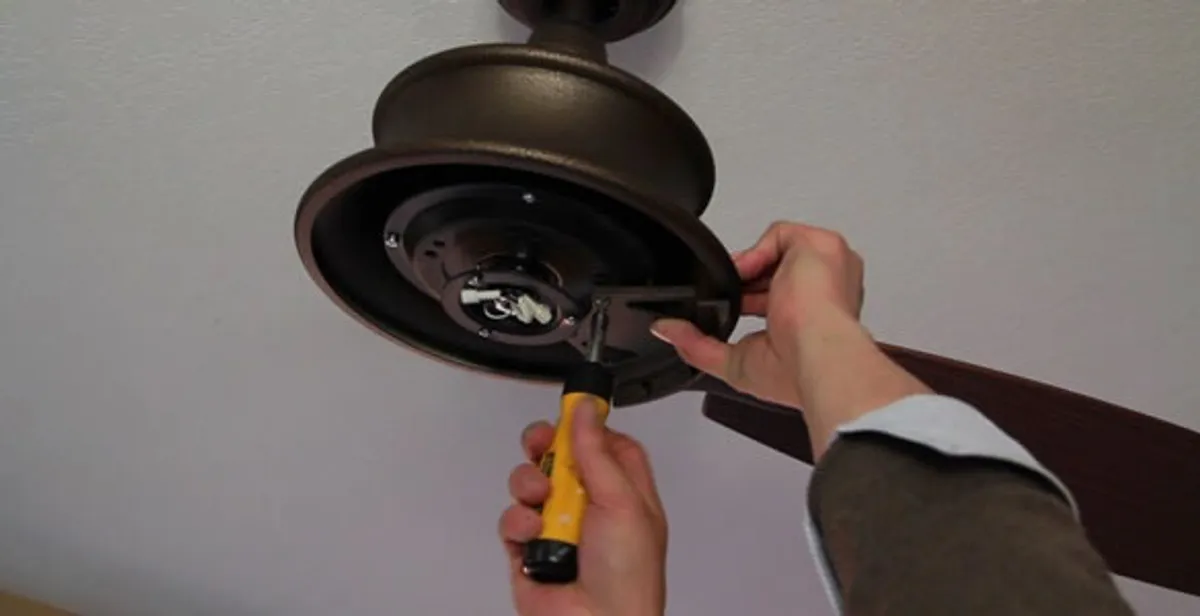 Electrician installing ceiling fan mounting bracket and fixture in Charlotte, NC