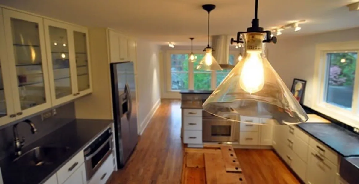 Residential electrician installing modern indoor light fixture in a home in Charlotte, NC